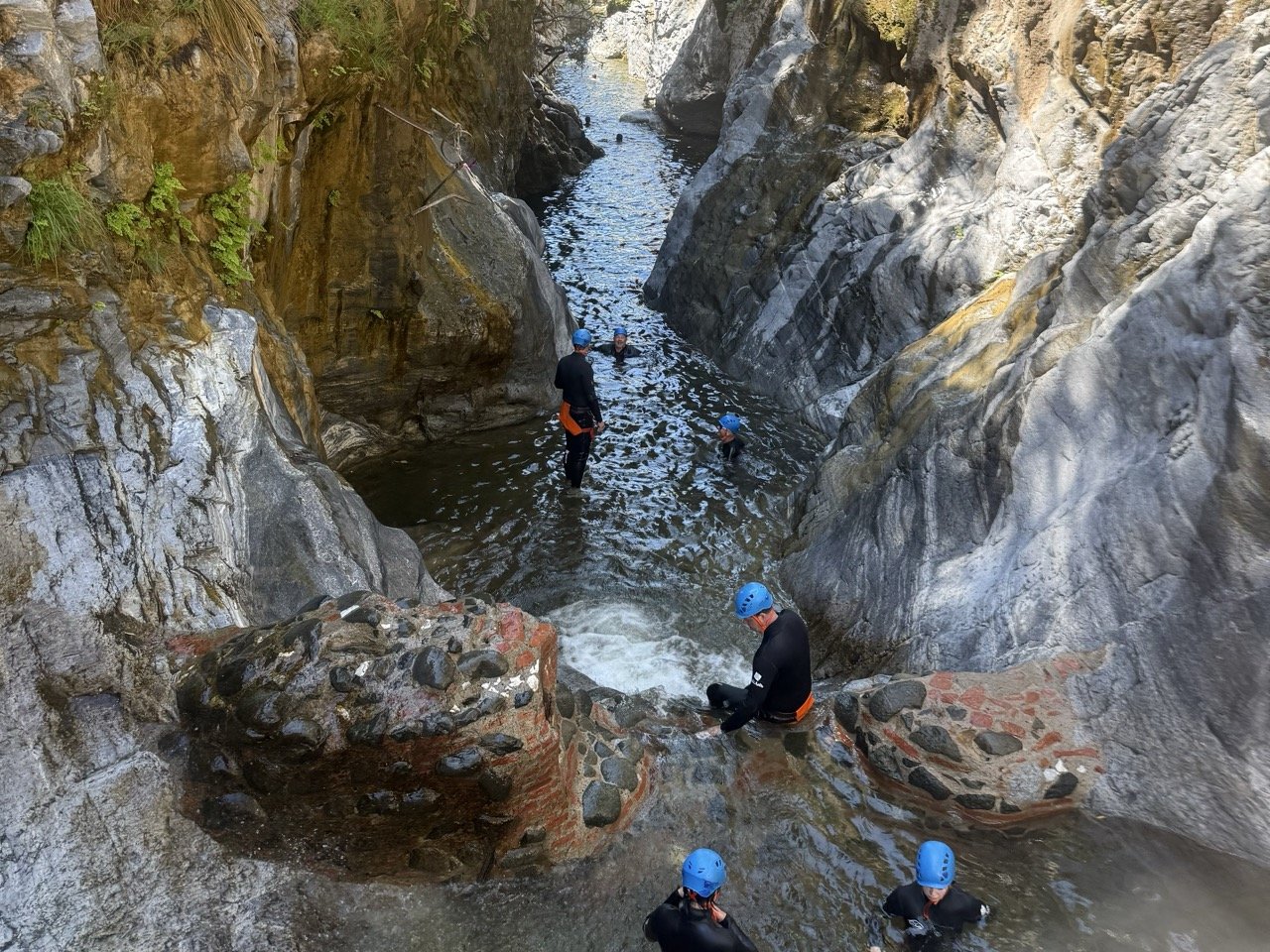 Mensen springen van een rots in een rivier bij Benahavís